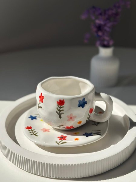 فنجان أبيض مع كوستر ورد